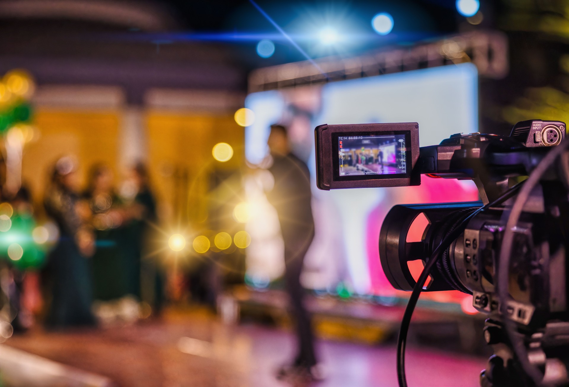 pov camcorder filming a stage with lights and lots of people, motivational speaker entertaining